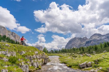  Fanes High Valley 'de, Alta Badia Dolomites, South Tirol ve Trentino, İtalya' daki Fanes-Sennes-Braies doğa parkında elektrikli dağ bisikletine binen son sınıf güzeli bir kadın.