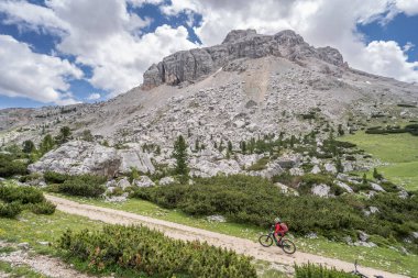 Fanes High Valley 'de, Alta Badia Dolomites, South Tirol ve Trentino, İtalya' daki Fanes-Sennes-Braies doğa parkında elektrikli dağ bisikletine binen son sınıf güzeli bir kadın.