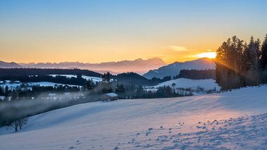 Avusturya 'nın Vorarlberg kentindeki Bregenzer Wald bölgesinde gün batımı. İsviçre' nin Saentis Dağı 'nın muhteşem manzarası.