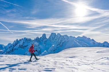 Prato Piazzo 'dan Monte Specie' ye kadar uzanan ünlü Üç Tepe 'nin altında kar ayakkabısı giyen güzel aktif bir kadın. Arka planda Monte Cristallo Zirvesi ile Innichen köyü yakınlarındaki üç meşe ağacı Dolomite bölgesinde.