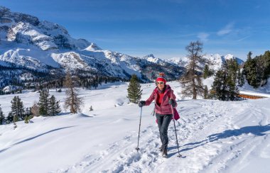 Prato Piazzo 'dan Monte Specie' ye kadar uzanan ünlü Üç Tepe 'nin altında kar ayakkabısı giyen aktif son sınıf öğrencisi bir kadın. İtalya' nın güneyindeki Innichen kasabası yakınlarındaki üç meşe Dolomite bölgesinde.