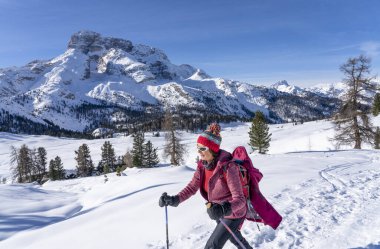 Prato Piazzo 'dan Monte Specie' ye kadar uzanan ünlü Üç Tepe 'nin altında kar ayakkabısı giyen aktif son sınıf öğrencisi bir kadın. İtalya' nın güneyindeki Innichen kasabası yakınlarındaki üç meşe Dolomite bölgesinde.