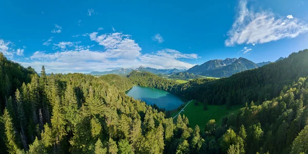 Almanya 'nın Bavyera eyaletinin Fuessen kenti yakınlarındaki doğu Allgaeu' deki Alatsee Gölü 'ndeki Alp arazisinin havadan çekilmiş fotoğrafı.