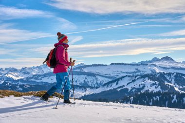 Almanya, Bavyera, Oberstaufen yakınlarındaki Allgau Alpleri 'nin dağlarında derin toz karda yürüyüş yapan hoş ve aktif bir son sınıf öğrencisi.
