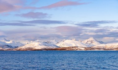 Norveç 'in kuzeyindeki Tromsoe yakınlarındaki Kvaloeya Adası' nda dramatik gökyüzü manzaralı kışın manzarası.