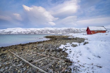 Norveç 'in kuzeyindeki Tromsoe yakınlarındaki Kvaloeya Adası' nda dramatik gökyüzü manzaralı kışın manzarası.