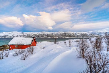 Norveç 'in kuzeyindeki Tromsoe yakınlarındaki Kvaloeya Adası' nda dramatik gökyüzü manzaralı kışın manzarası.