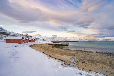 Norveç 'in kuzeyindeki Tromsoe yakınlarındaki Kvaloeya Adası' nda dramatik gökyüzü manzaralı kışın manzarası.