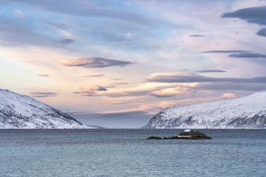 Norveç 'in kuzeyindeki Tromsoe yakınlarındaki Kvaloeya Adası' nda dramatik gökyüzü manzaralı kışın manzarası.