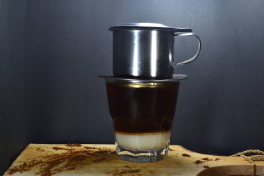 Vietnam kahvesi siyah arka planlı tahtalardan damlıyor.