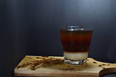 Bardağın altında kremalı sade kahve.