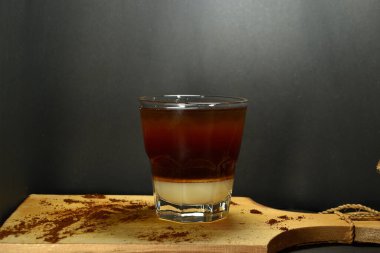 Bardağın altında kremalı sade kahve.