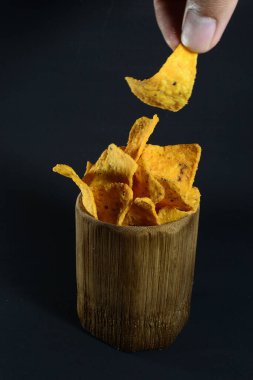 Siyah arka planda bambu camlı tortilla atıştırmalığı.