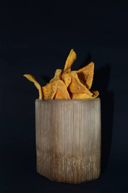 Siyah arka planda bambu camlı tortilla atıştırmalığı.