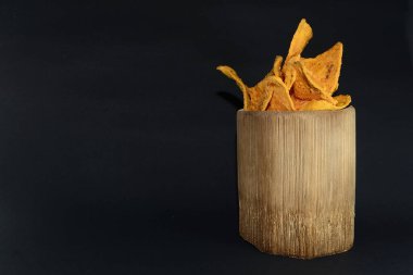 Siyah arka planda bambu camlı tortilla atıştırmalığı.