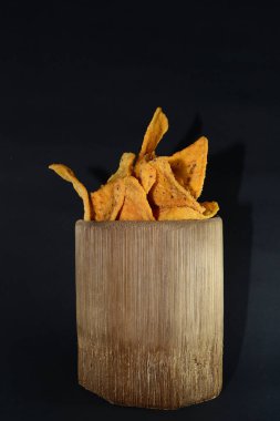 Siyah arka planda bambu camlı tortilla atıştırmalığı.
