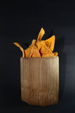 Siyah arka planda bambu camlı tortilla atıştırmalığı.