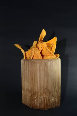 Siyah arka planda bambu camlı tortilla atıştırmalığı.