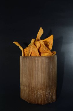 Siyah arka planda bambu camlı tortilla atıştırmalığı.