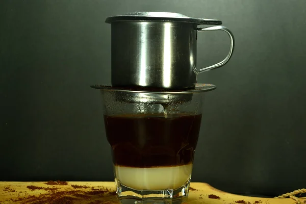 Vietnamese coffee drip on wooden planks with black background