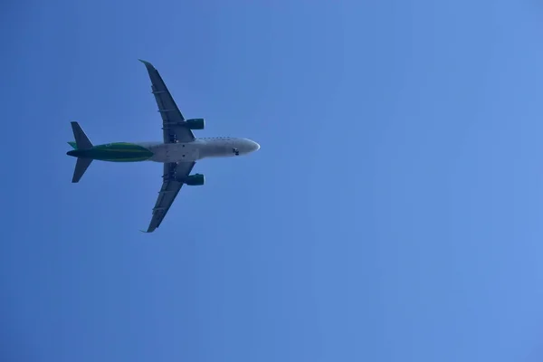 Uçak mavi gökyüzünde uçuyor.