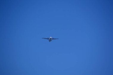 Uçak mavi gökyüzünde uçuyor.