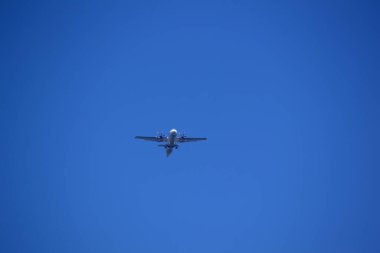 Uçak mavi gökyüzünde uçuyor.