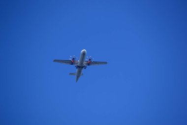 Uçak mavi gökyüzünde uçuyor.