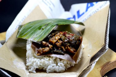 Endonezya 'dan geleneksel gıda aşçısı Nasi kucing, küçük, yumruk büyüklüğünde pirinç ve malzemelerden oluşur..