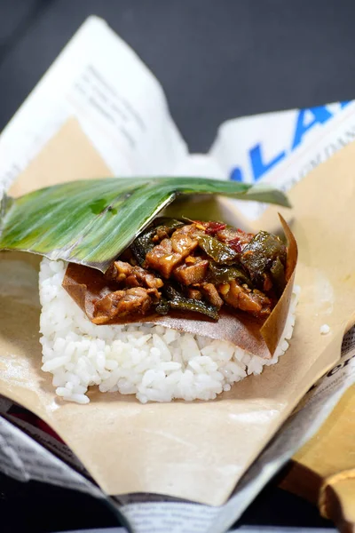 Endonezya 'dan geleneksel gıda aşçısı Nasi kucing, küçük, yumruk büyüklüğünde pirinç ve malzemelerden oluşur..