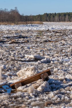 Nehrin tüm genişliği buz kütleleri ve denize akan buz vadileriyle doludur. Buz küpleriyle birlikte ahşap bir bank akıyor..