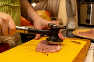 Domuz pirzolası havada uçan bir baharat çekiciyle dövülür.