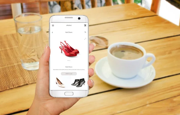Интернет покупки со смартфона. Изолированный телефон в руке женщины. Покупка женской обуви в интернет-магазине . — стоковое фото
