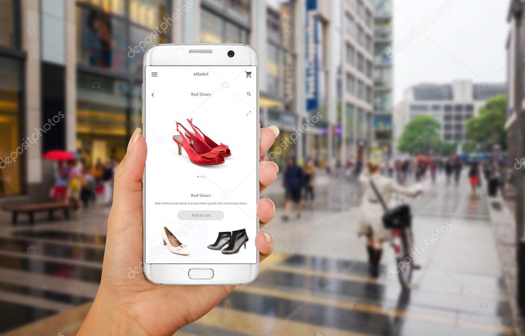 Online shopping with smart phone. Phone in woman hand. Buying women shoes on online store. Street walk and visiting shopping malls.