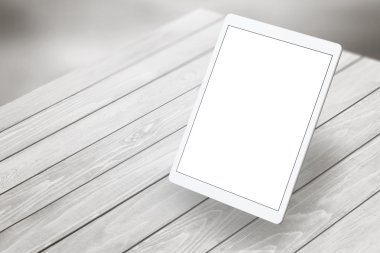 Tablet with white isolated screen on wooden desk. Isometric view 