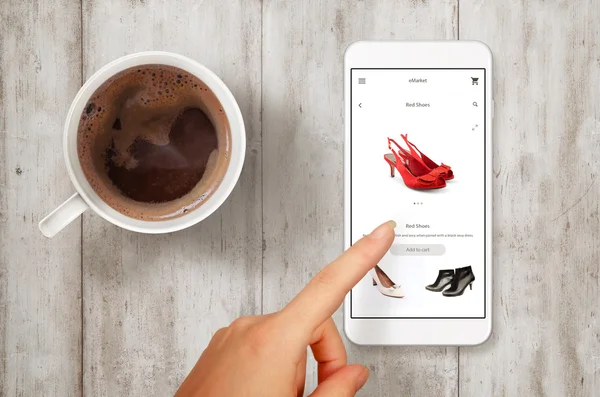 Женщина покупает обувь со смартфона. Сцена с видом сверху на кофе . — стоковое фото