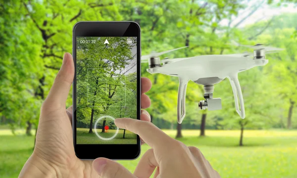 Smart phone control drone with app. Park in background.