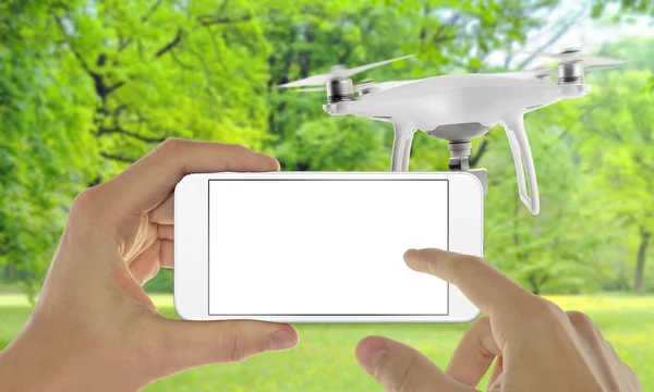 Smart phone with isolated white screen control drone with app. Park in background.