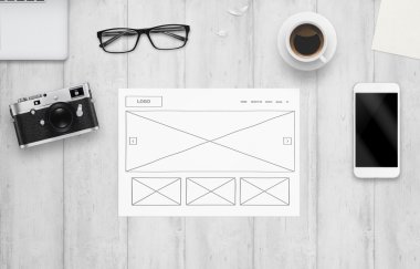 Kağıt üzerine çizilmiş web sitesinin planı. Çalışma Masası bilgisayar, telefon, kamera, gözlük, kahve ile Üstten Görünüm.