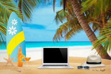 Plaj yaz saati üstünde laptop üzerinde çalışmak. Mockup için boş ekran.