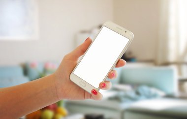 Modern beyaz akıllı telefon oturma odası iç kadın elinde.