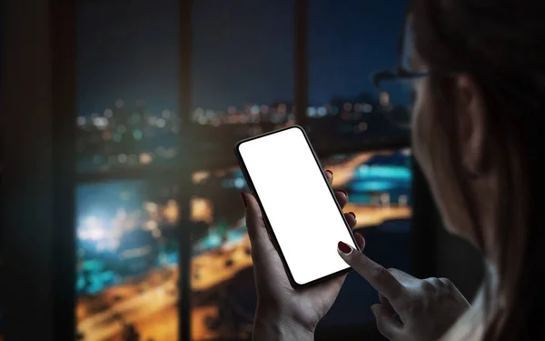 Woman use smart phone by the window. City lights in background. Isolated display for mockup, app design promotion