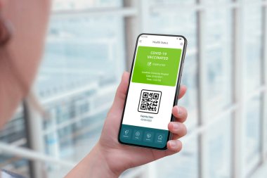 Coronavirus aşıları sertifikalı uygulama arayüzü kavramı QR kodu ile kadın elinde akıllı telefon