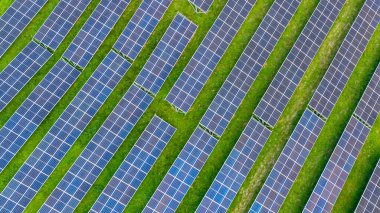 Modern fotovoltaik güneş panellerinin insansız hava aracı görüntüsü yeşil alanda yenilenebilir enerji üretiyor