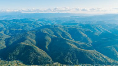 Wide aerial panorama of forested hills stretching to the distant horizon