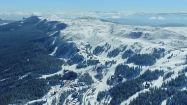 Ormanlar ve dolambaçlı kayak yolları ile Jahorina dağ kayak alanı açık kış gökyüzü altında panoramik manzara