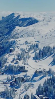 Sandalyeli ve kayak yamaçlı kayak merkezinin insansız hava görüntüsü.