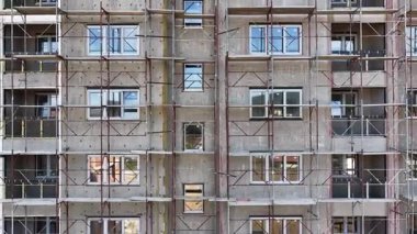 Hava aracı videosu yapı iskelesi, yenileme ve inşaat işleriyle apartman cephesinden yavaşça geri çekiliyor.