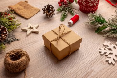 Paketli bir hediye ve kış süslemeleri olan şenlikli masa başı Noel sahnesi, yaşam tarzı içeriği, mevsimlik bloglar ve rahat tatil görselleri için ideal