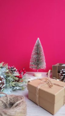 Yavaş çekim kamerası hediye kutusuyla Noel masasında hareket ederek sıcak ve sinematik bir tatil atmosferi yaratıyor.